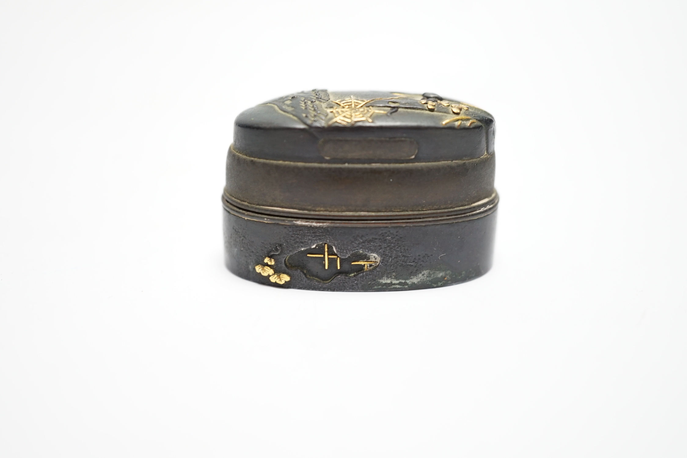 A Japanese mixed metal and bronze box made from 19th century sword fittings, decorated with a spider and web, 4cm